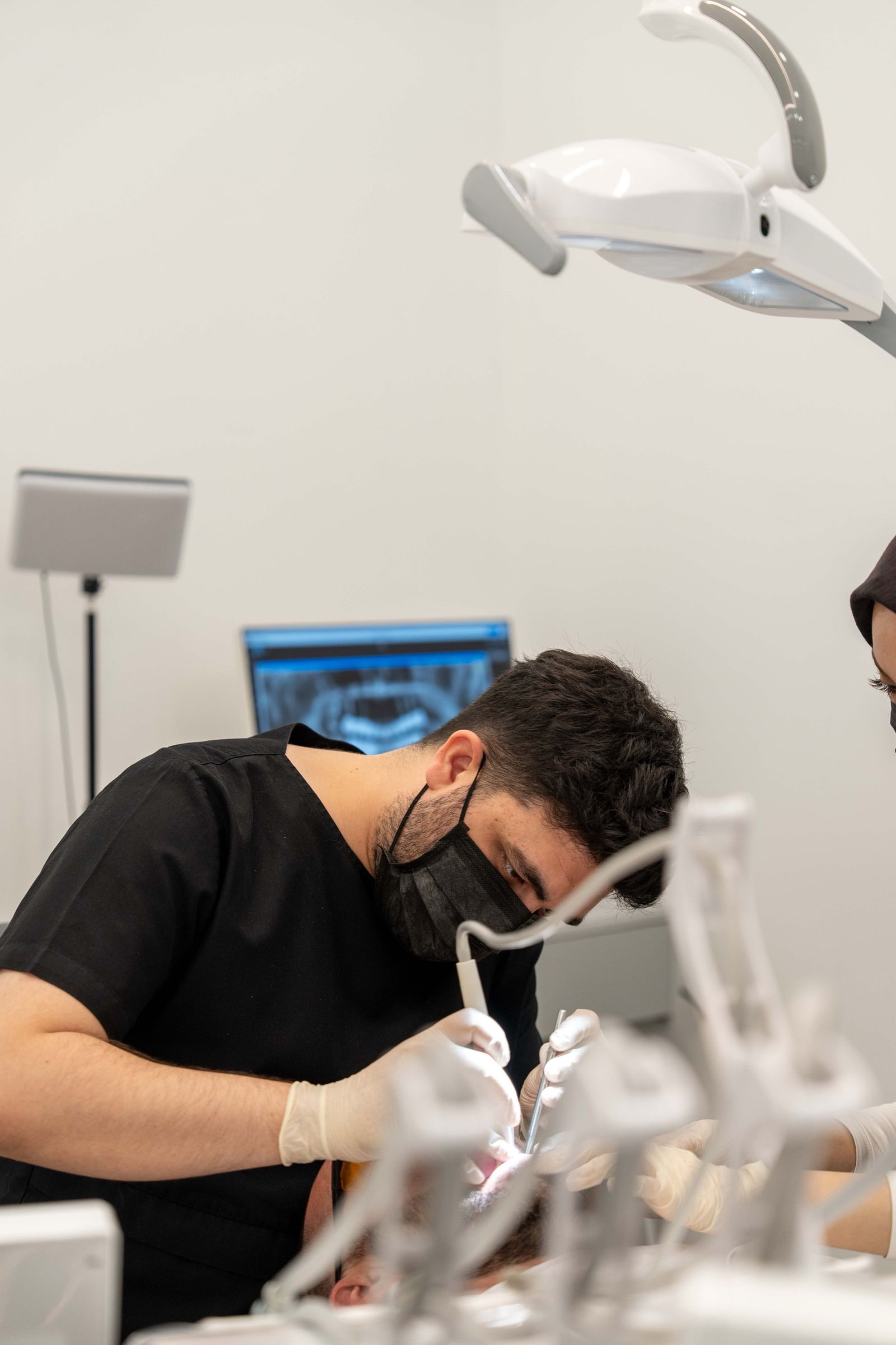 A dentist at work in a treatment room at TORA Clinic.